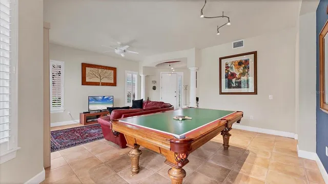 a living room with a table and paintings on the wall