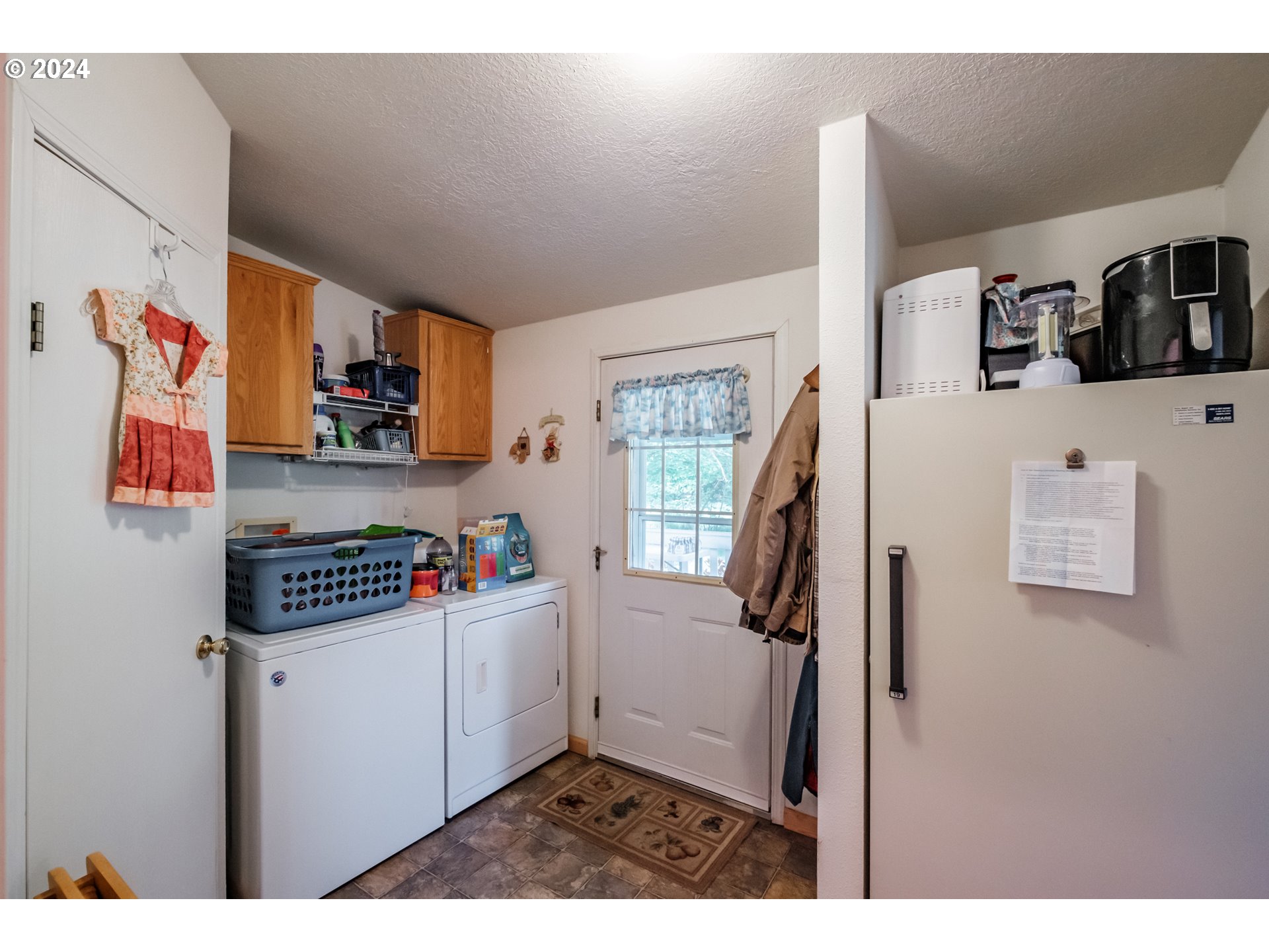 8560 Southeast Wallace Road Dayton, OR 97114 - Photo 33 of 48 a kitchen with a refrigerator and white cabinets