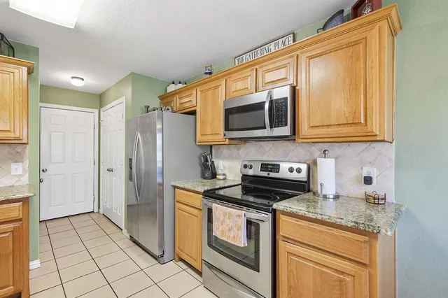 a kitchen with stainless steel appliances granite countertop a stove and a microwave