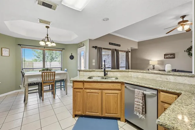 a kitchen with granite countertop a stove a sink and a microwave