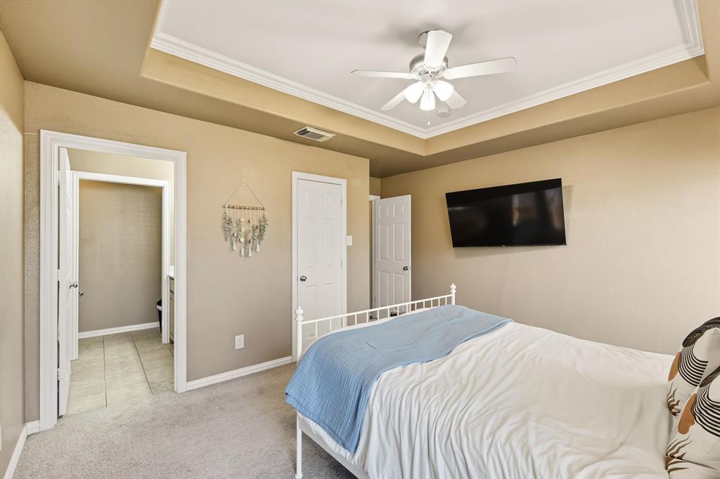 100 Turtle Dove Krum, TX 76249 - Photo 27 of 40 a bedroom with a bed and a flat screen tv