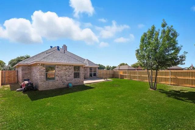 a view of a garden with a house in the background