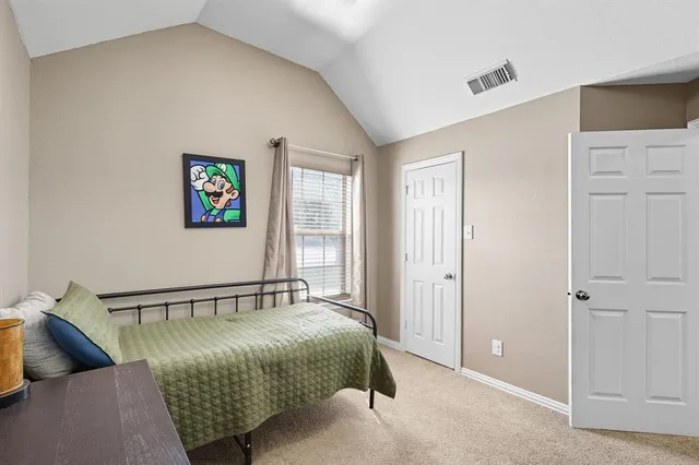 a bedroom with a bed and painting on the wall