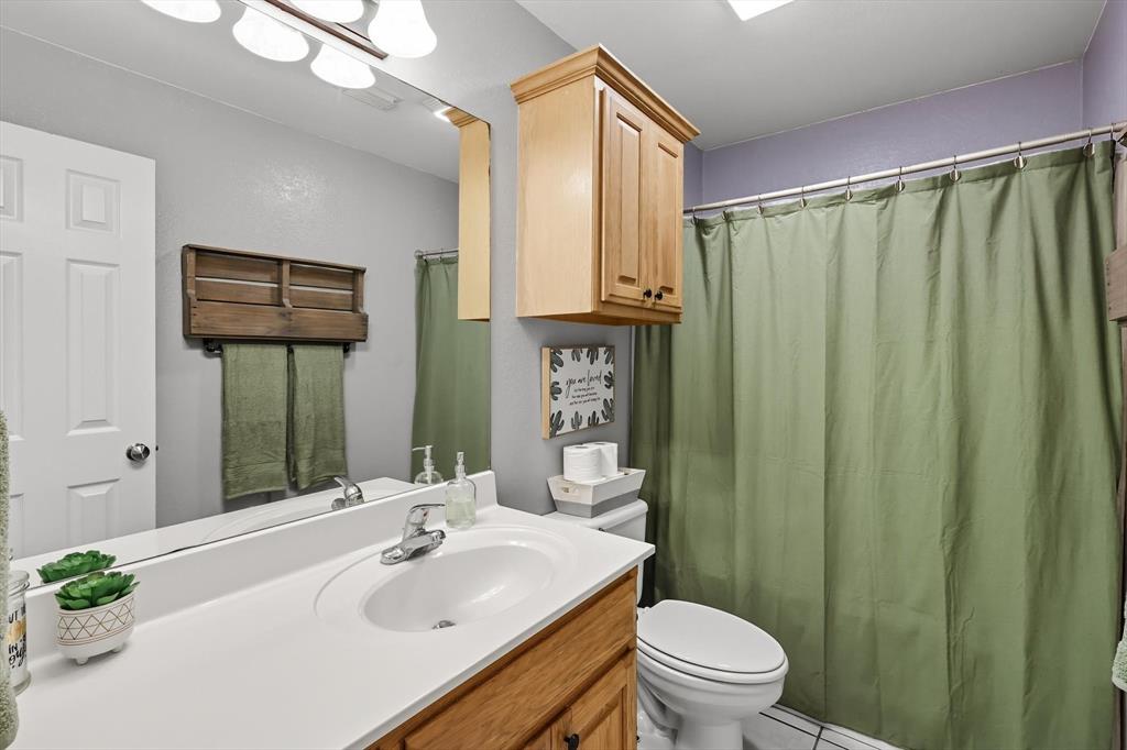 100 Turtle Dove Krum, TX 76249 - Photo 10 of 40 a bathroom with a sink a toilet and shower curtain