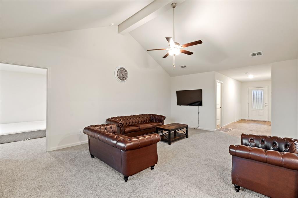 8216 Columbia Falls Road Ponder, TX 76259 - Photo 11 of 28 Carpeted living area featuring baseboards, ceiling fan, beamed ceiling, and visible vents