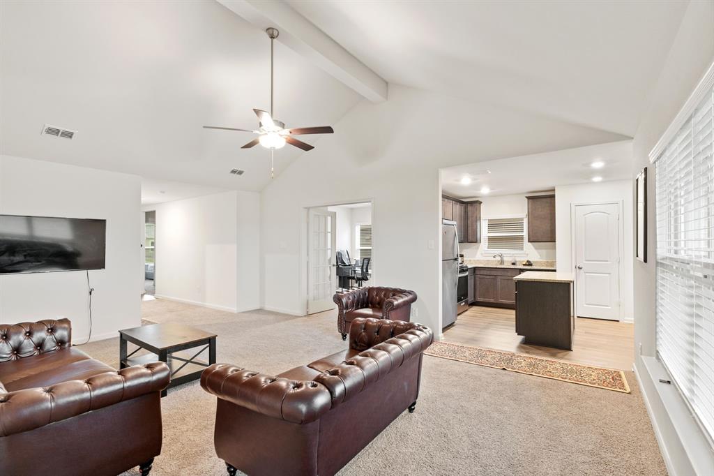 8216 Columbia Falls Road Ponder, TX 76259 - Photo 12 of 28 Living area featuring visible vents, beam ceiling, light carpet, high vaulted ceiling, and a ceiling fan