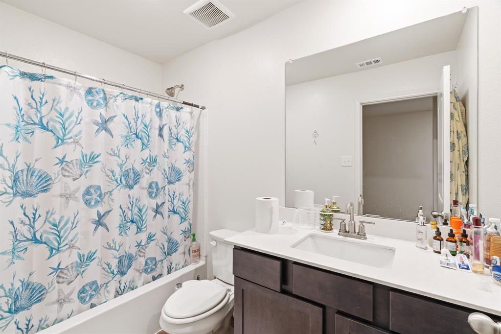 8216 Columbia Falls Road Ponder, TX 76259 - Photo 15 of 28 Bathroom with vanity, shower / bath combination with curtain, toilet, and visible vents