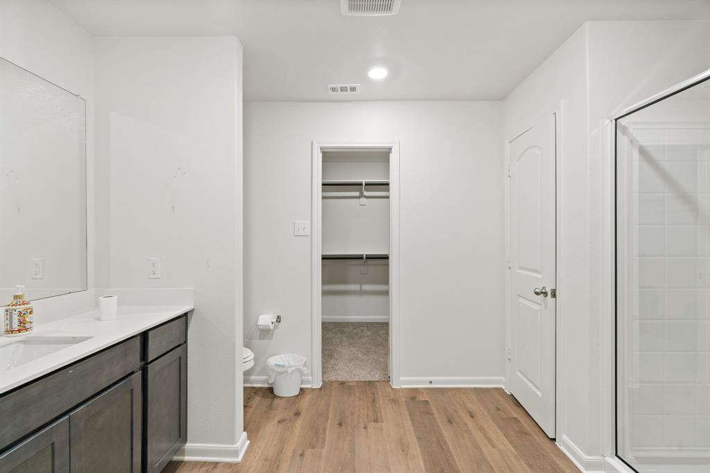 8216 Columbia Falls Road Ponder, TX 76259 - Photo 21 of 28 Full bath featuring walk in shower, a walk in closet, toilet, wood finished floors, and visible vents