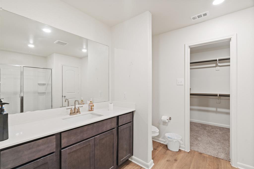 8216 Columbia Falls Road Ponder, TX 76259 - Photo 24 of 28 Bathroom featuring visible vents, wood finished floors, toilet, recessed lighting, and a stall shower