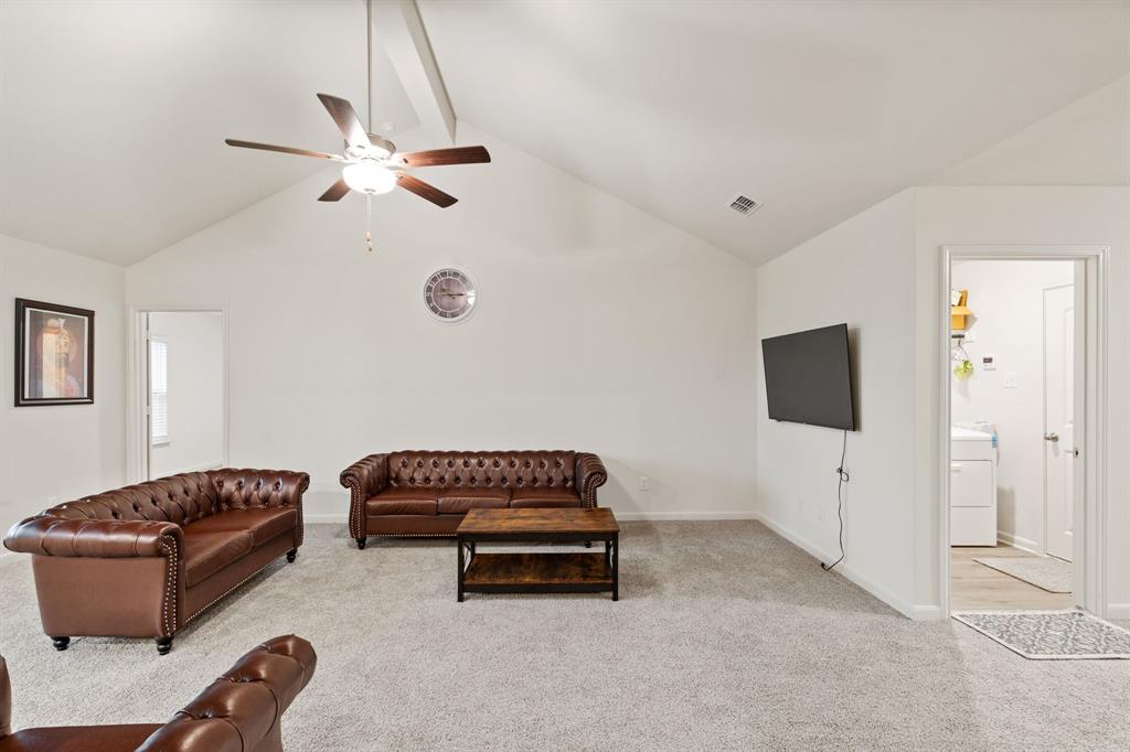 8216 Columbia Falls Road Ponder, TX 76259 - Photo 8 of 28 Carpeted living room featuring high vaulted ceiling, a ceiling fan, baseboards, washer / dryer, and visible vents