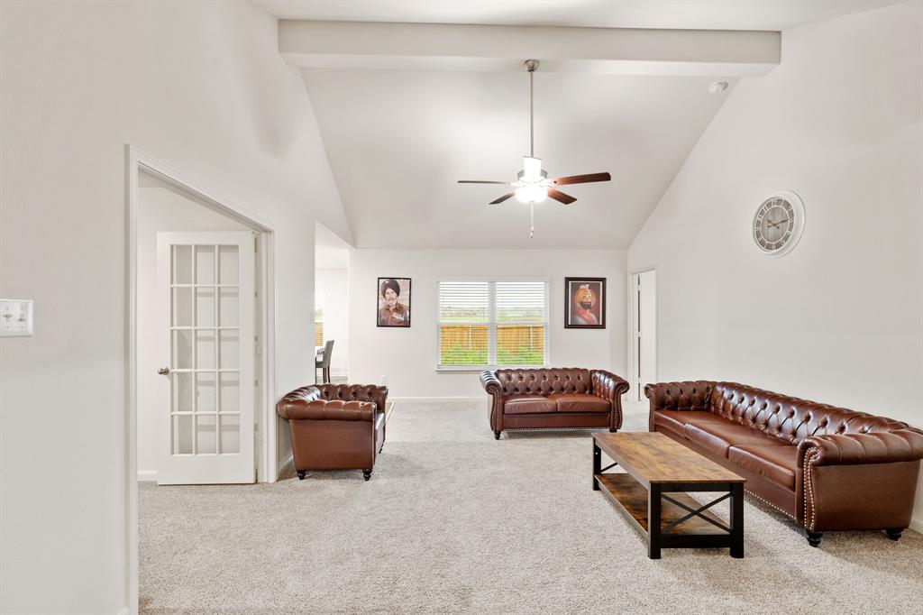 8216 Columbia Falls Road Ponder, TX 76259 - Photo 10 of 28 Carpeted living room with high vaulted ceiling, ceiling fan, beamed ceiling, and baseboards