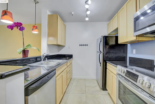 a kitchen with stainless steel appliances granite countertop a sink stove and refrigerator