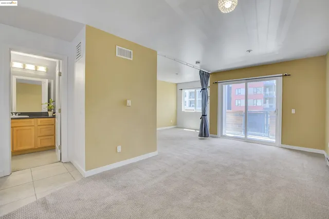 an empty room with a kitchen view and a microwave