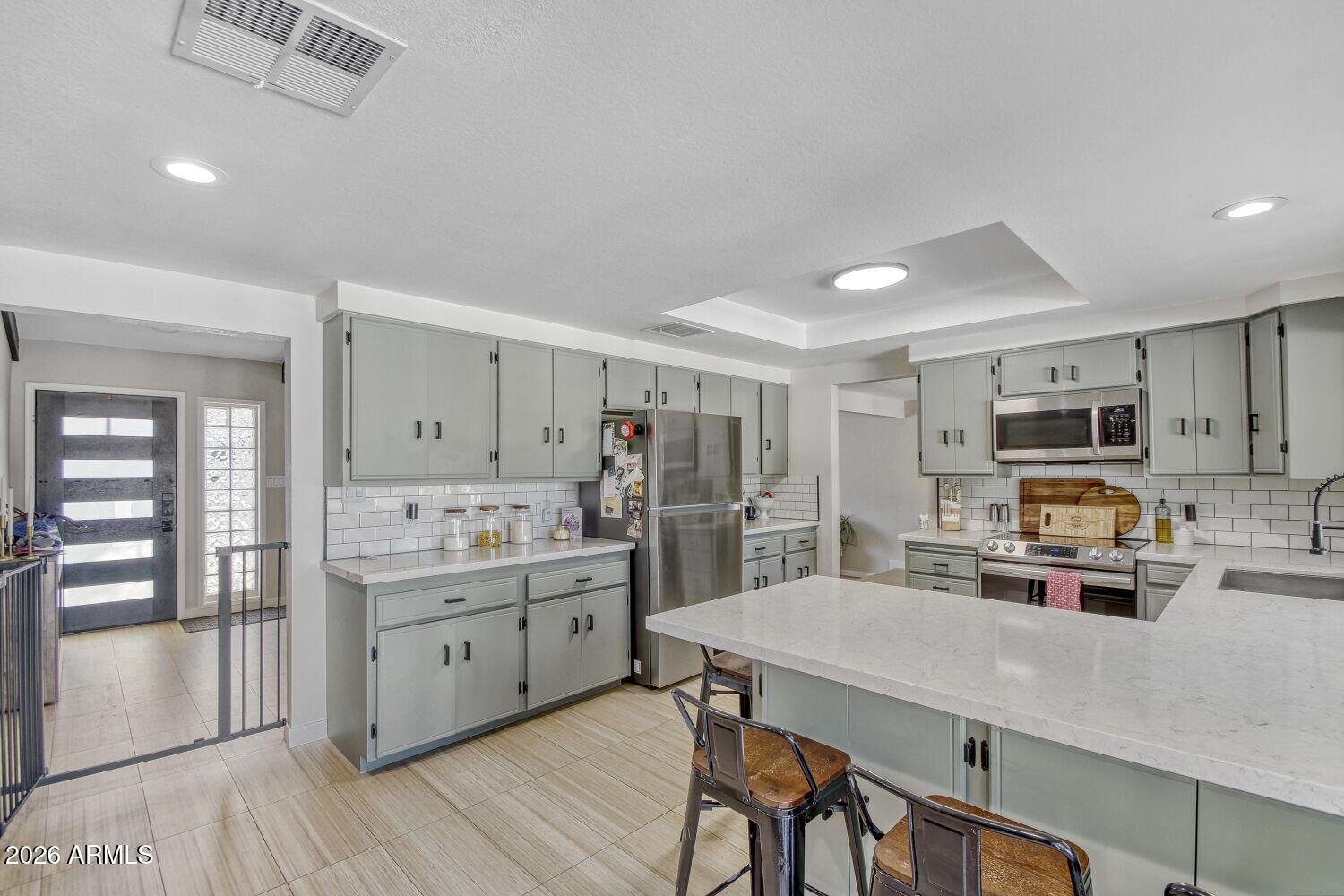 720 West Thunderbird Road Phoenix, AZ 85023 - Photo 10 of 28 a kitchen with stainless steel appliances a sink a stove a refrigerator cabinets and a dining table
