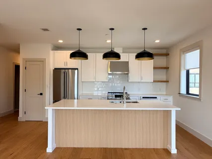 a kitchen with stainless steel appliances granite countertop a sink a refrigerator and a stove