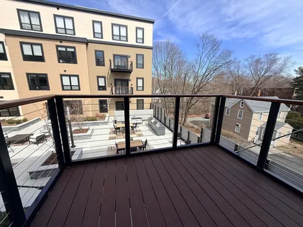 a view of a balcony with wooden floor and fence