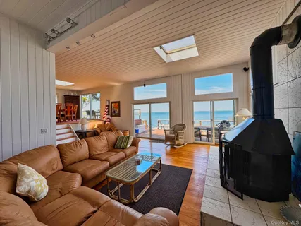 a living room with furniture kitchen view and a large window