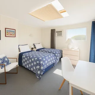 a bedroom with two beds and a chair