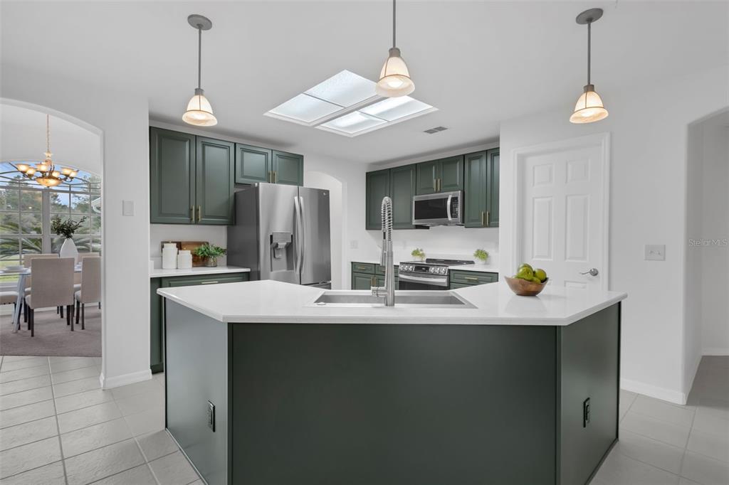 15038 Willow Lane Tavares, FL 32778 - Photo 12 of 37 a kitchen with a sink a refrigerator and chairs