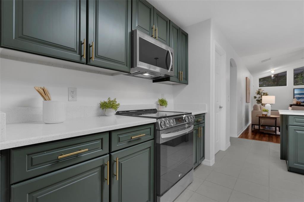 15038 Willow Lane Tavares, FL 32778 - Photo 13 of 37 a kitchen with stainless steel appliances a stove microwave and cabinets