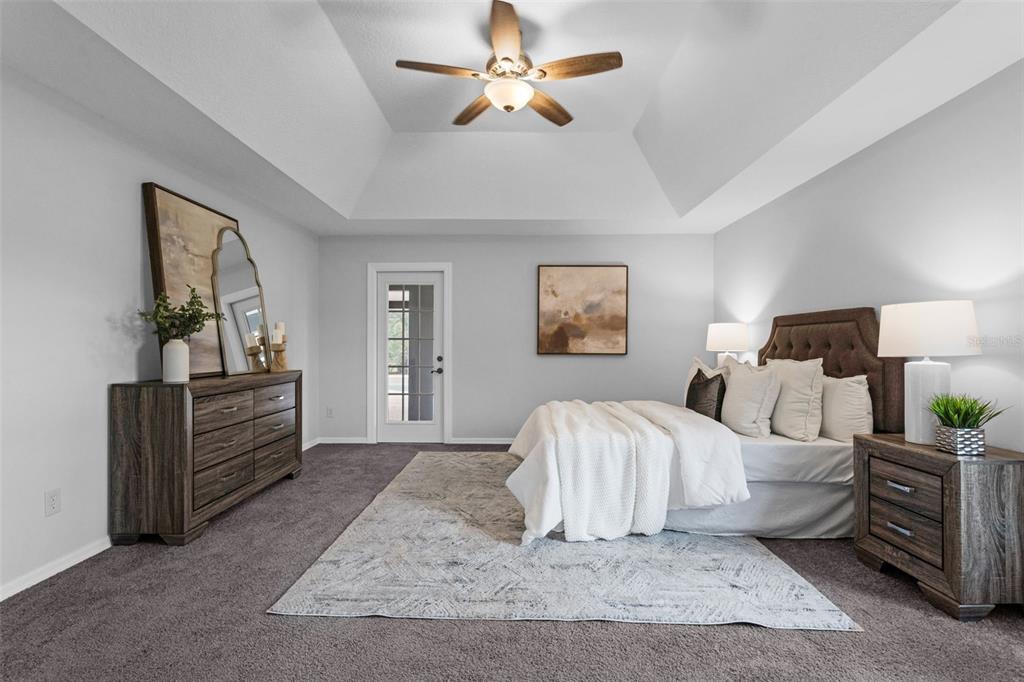 15038 Willow Lane Tavares, FL 32778 - Photo 16 of 37 a spacious bedroom with a bed and a chandelier