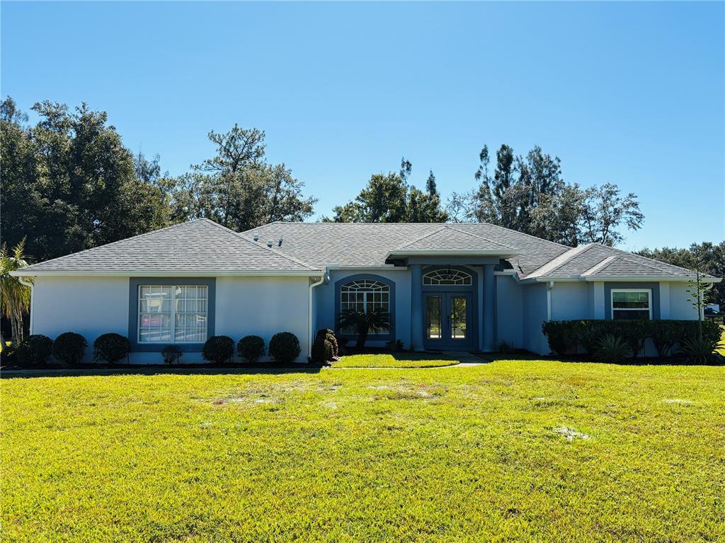 15038 Willow Lane Tavares, FL 32778 - Photo 2 of 37 a front view of house with yard and trees in the background