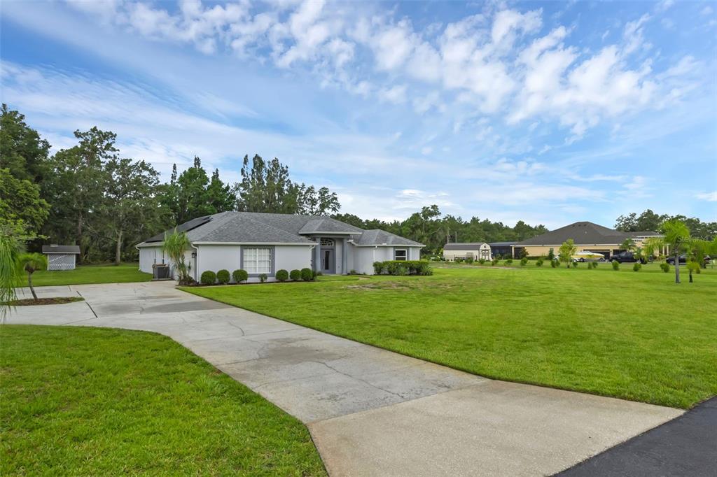 15038 Willow Lane Tavares, FL 32778 - Photo 36 of 37 a view of a big house with a big yard and potted plants