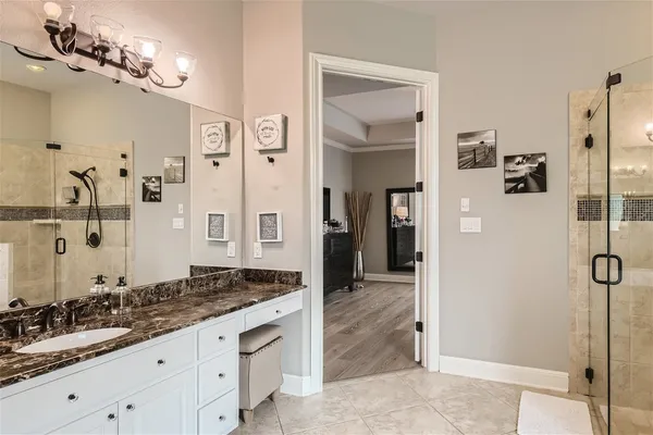 a spacious bathroom with a granite countertop sink a mirror and shower