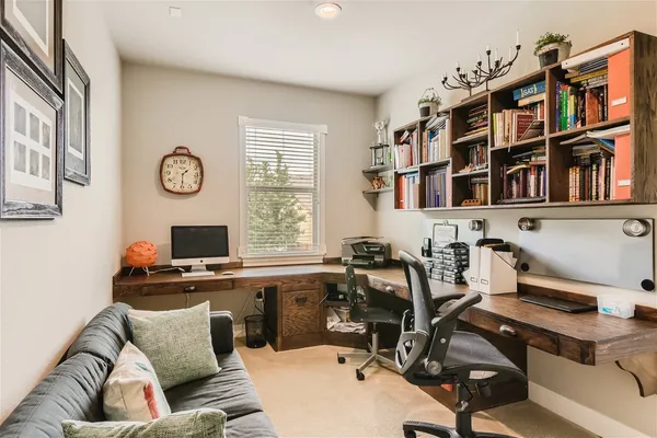 a view of a workspace with furniture and a window