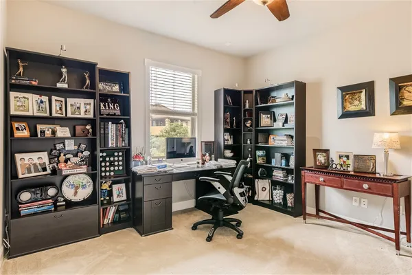 a view of a workspace with furniture and a bookshelf