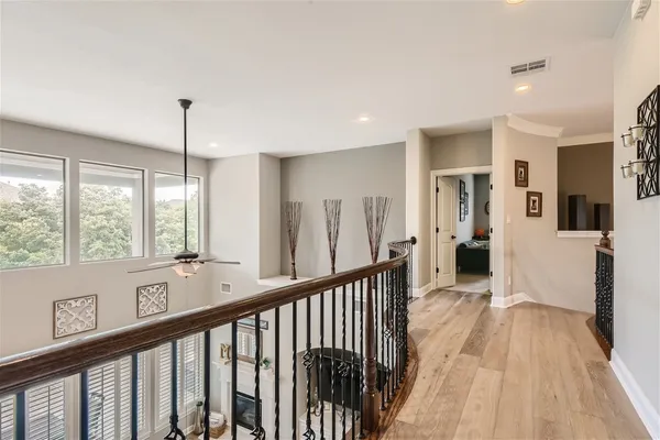 a view of hallway with wooden floor and windows