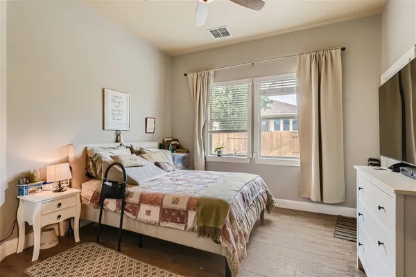 a bedroom with a bed and a flat tv screen on dresser