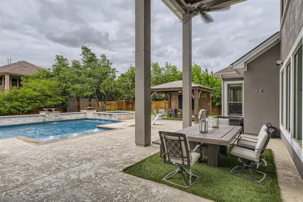 a view of a patio with a table chairs and a floor to ceiling window