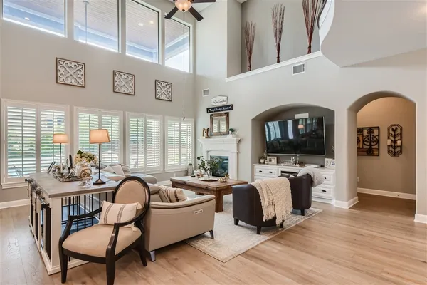 a living room with furniture a flat screen tv and wooden floor