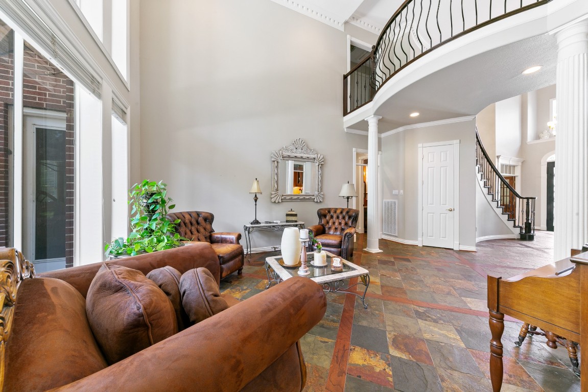 13915 Springmint Drive Cypress, TX 77429 - Photo 8 of 43 Soaring ceilings and a sweeping staircase with wrought iron railing create a dramatic open-to-below design, accented by double-story windows and elegant slate flooring