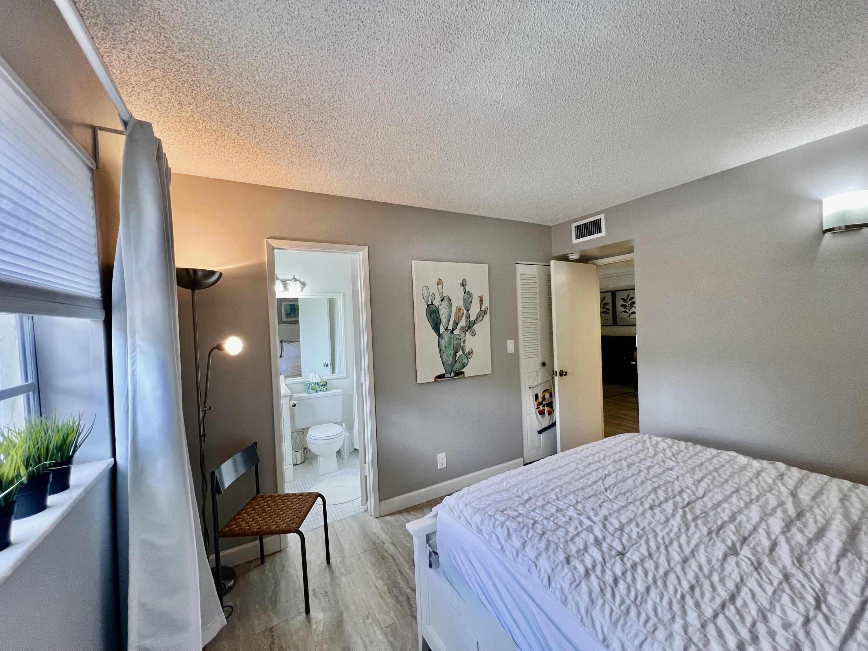 5640 Southwest 3rd Place, Unit 217 Margate, FL 33068 - Photo 12 of 32 a bedroom with a bed and a mirror