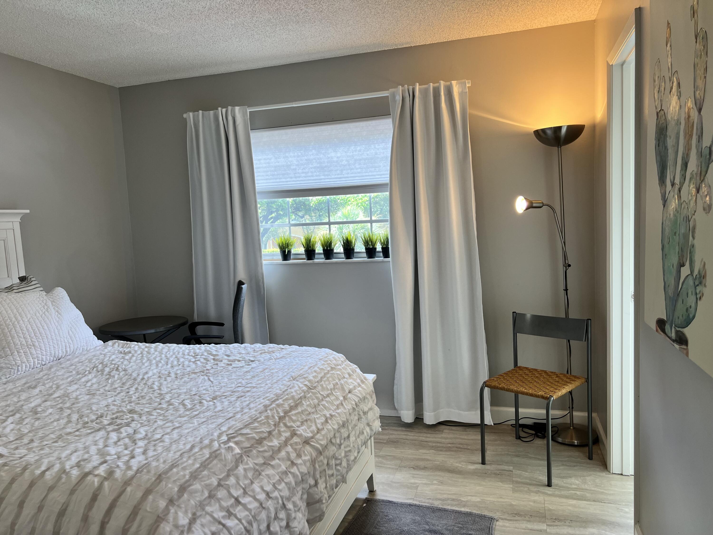 5640 Southwest 3rd Place, Unit 217 Margate, FL 33068 - Photo 13 of 32 a bedroom with a bed a mirror and a window