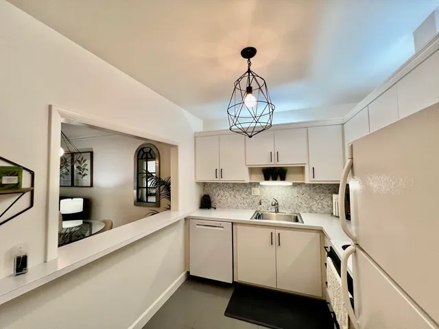 a kitchen with kitchen island white cabinets and white appliances