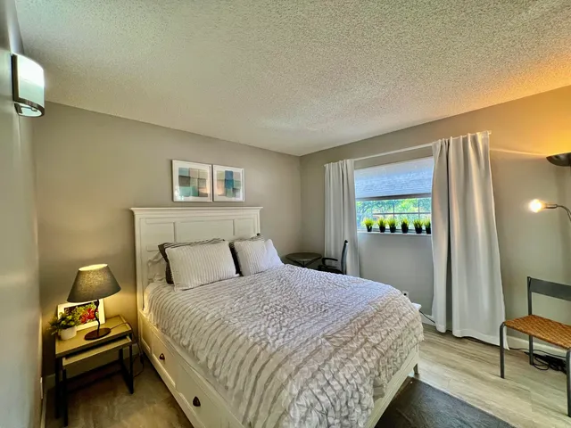 a bedroom with a bed and a lamp on table