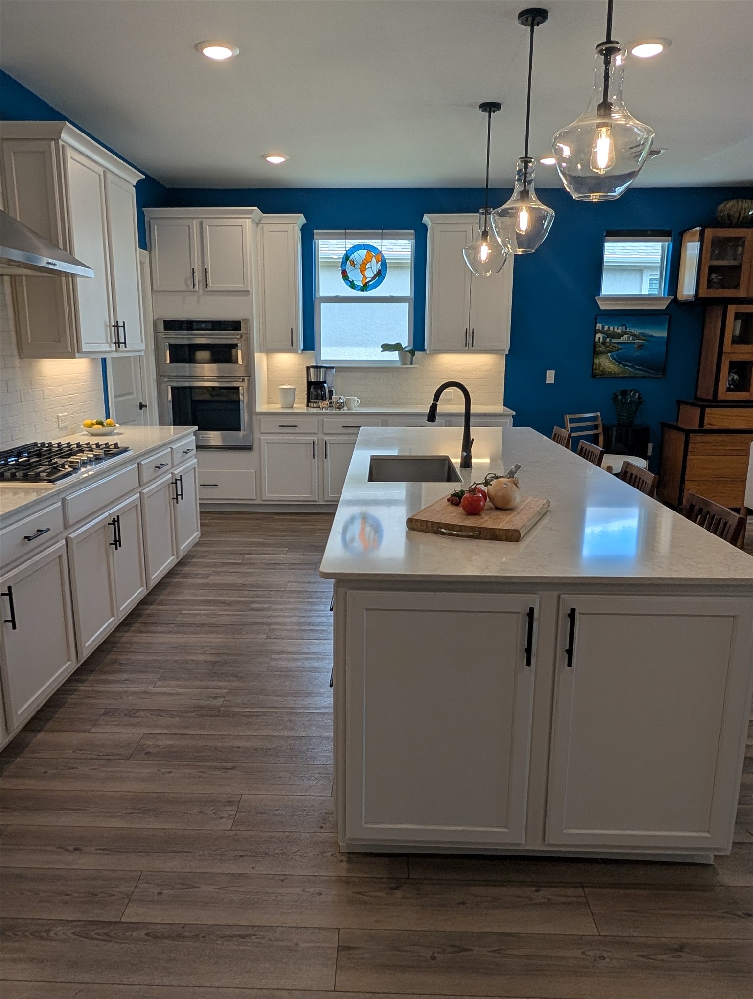 336 Kitty Hawk Road Georgetown, TX 78633 - Photo 14 of 40 An expansive kitchen island anchors this modern cooking space finished with wood-plank flooring.