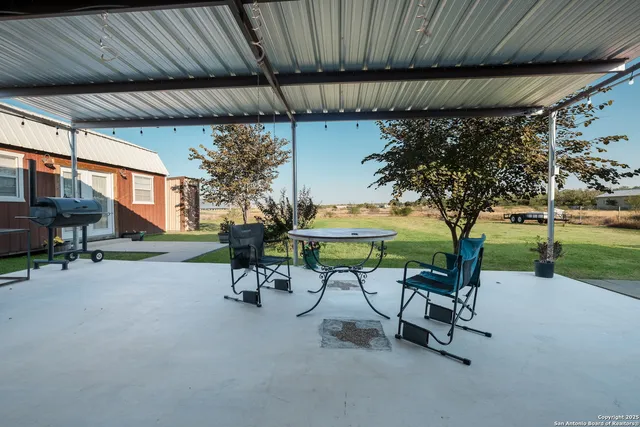 a aerial view of a house with a big yard potted plants and large tree