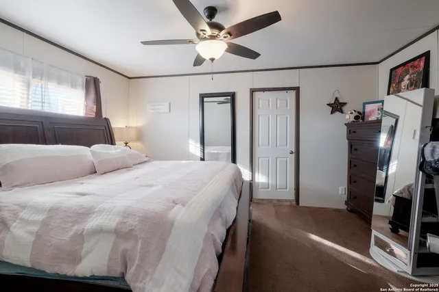 a bedroom with a large bed chandelier and a window
