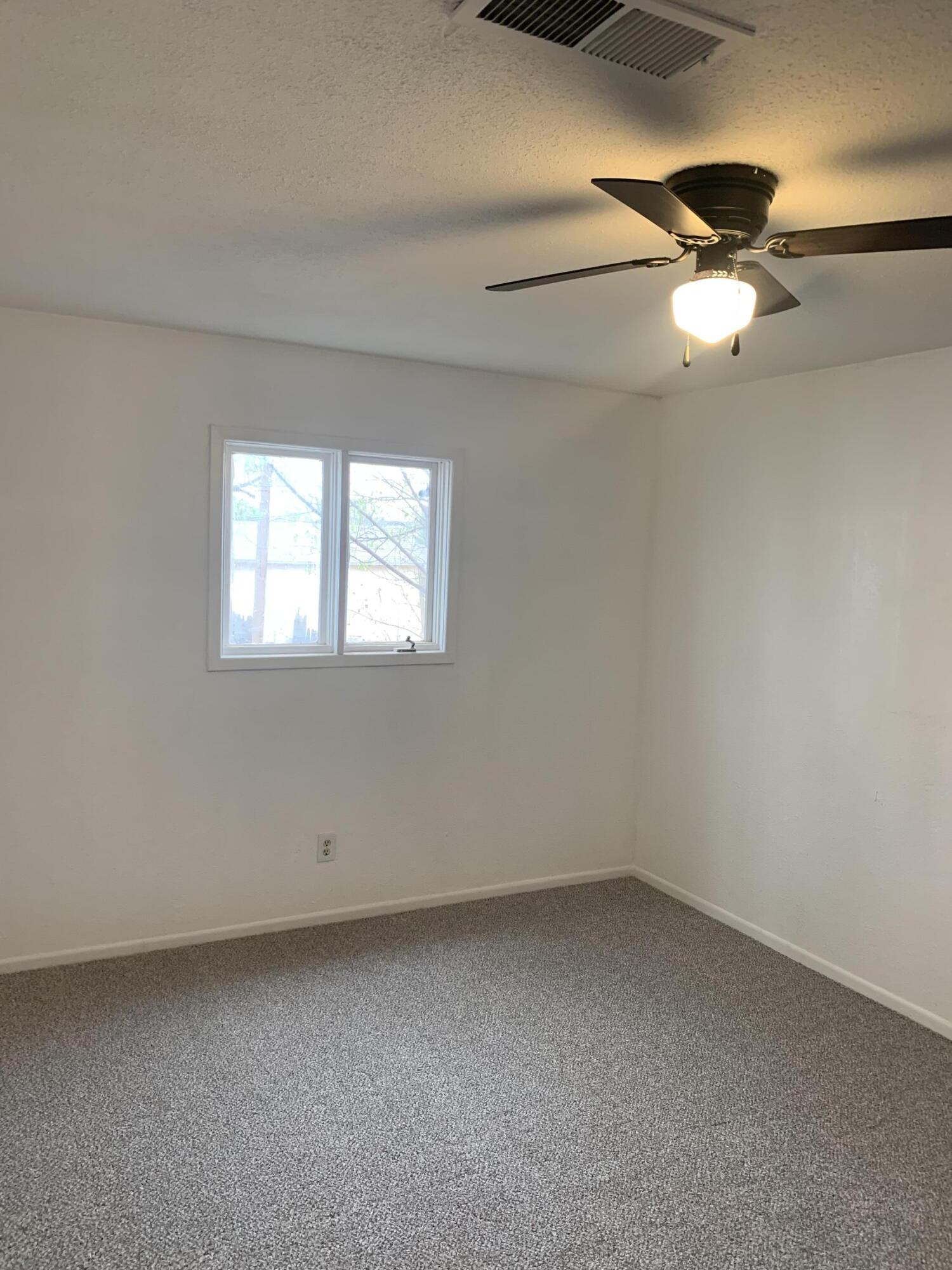 750 South 13th Street Slaton, TX 79364 - Photo 12 of 13 wooden floor in an empty room with a window