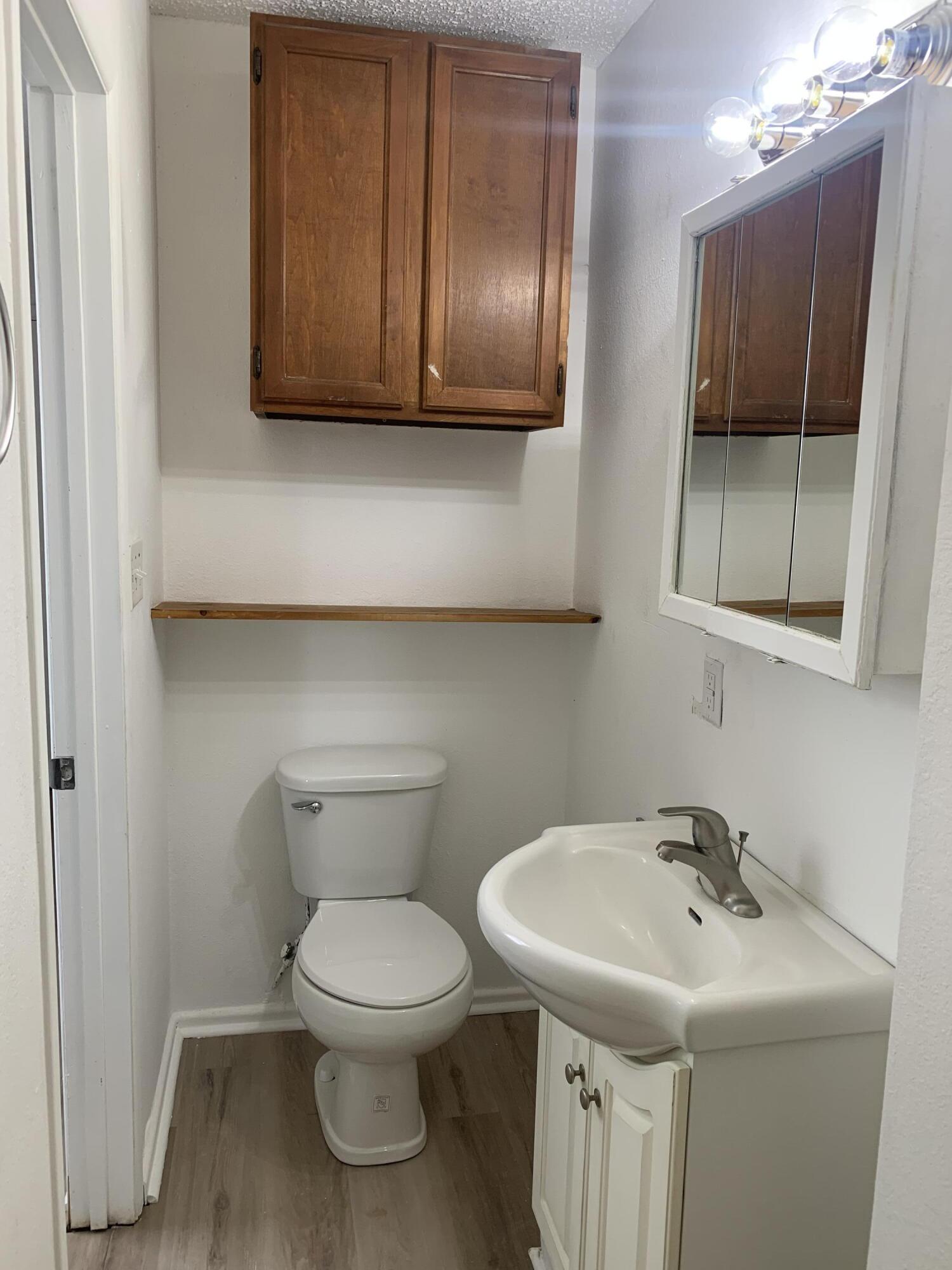 750 South 13th Street Slaton, TX 79364 - Photo 13 of 13 a bathroom with a toilet a sink and mirror