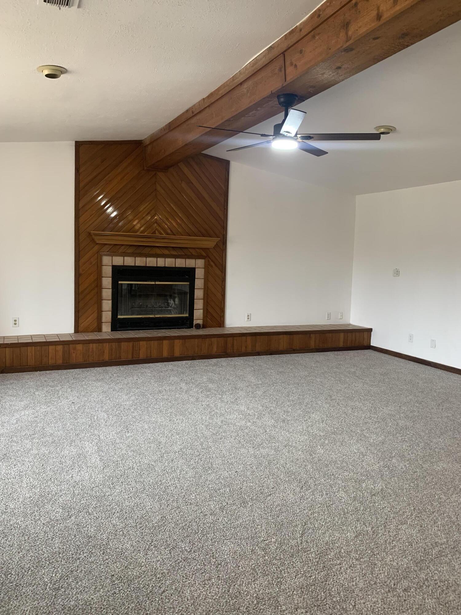 750 South 13th Street Slaton, TX 79364 - Photo 3 of 13 a view of an empty room with a fireplace and a window