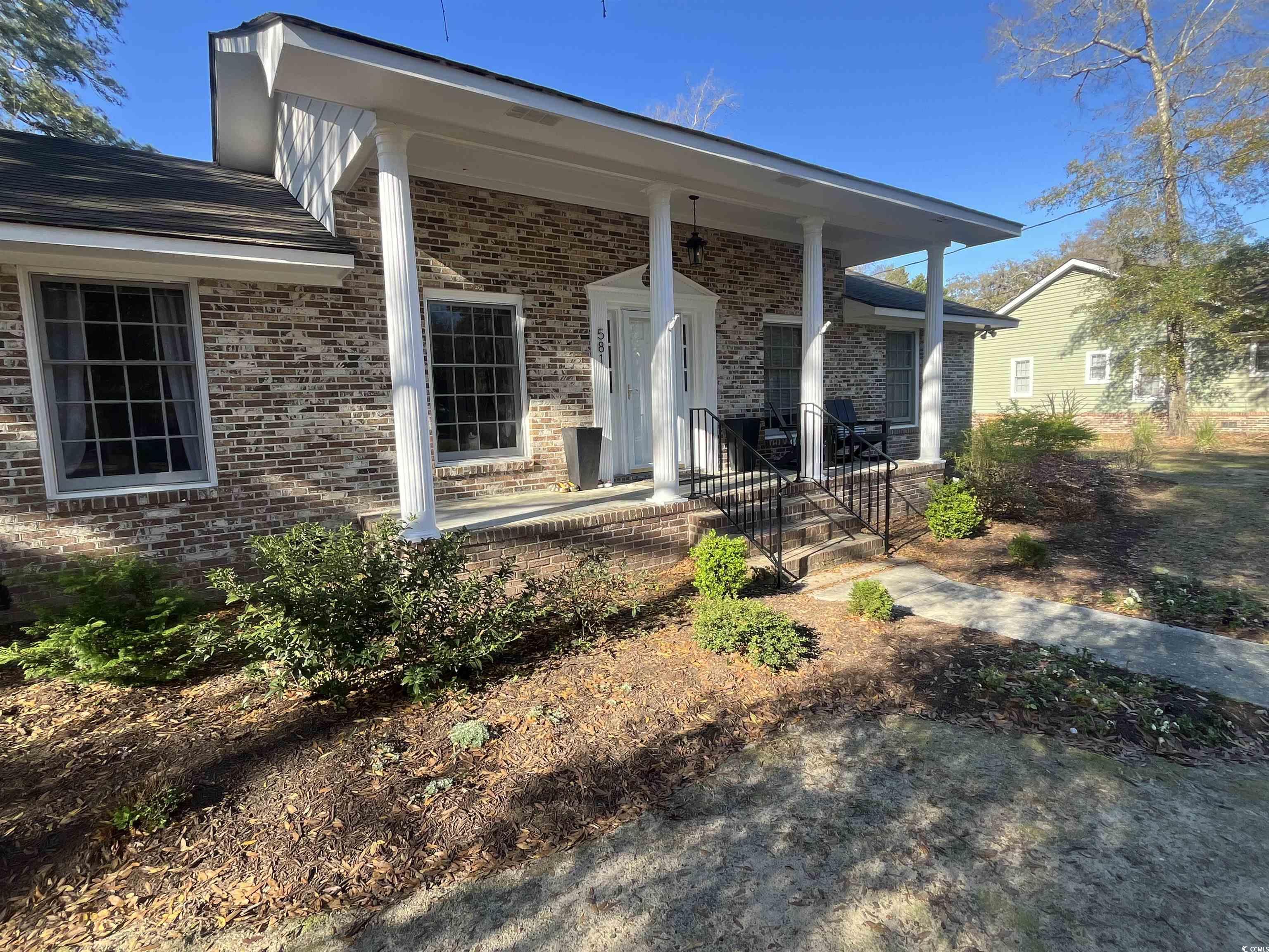 581 Vaux Hall Avenue Murrells Inlet, SC 29576 - Photo 2 of 2 View of exterior entry with brick siding and cover