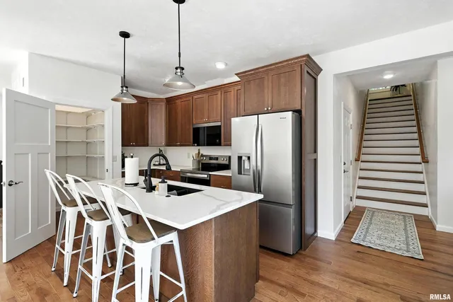 a kitchen with stainless steel appliances a refrigerator a sink a stove a microwave and island