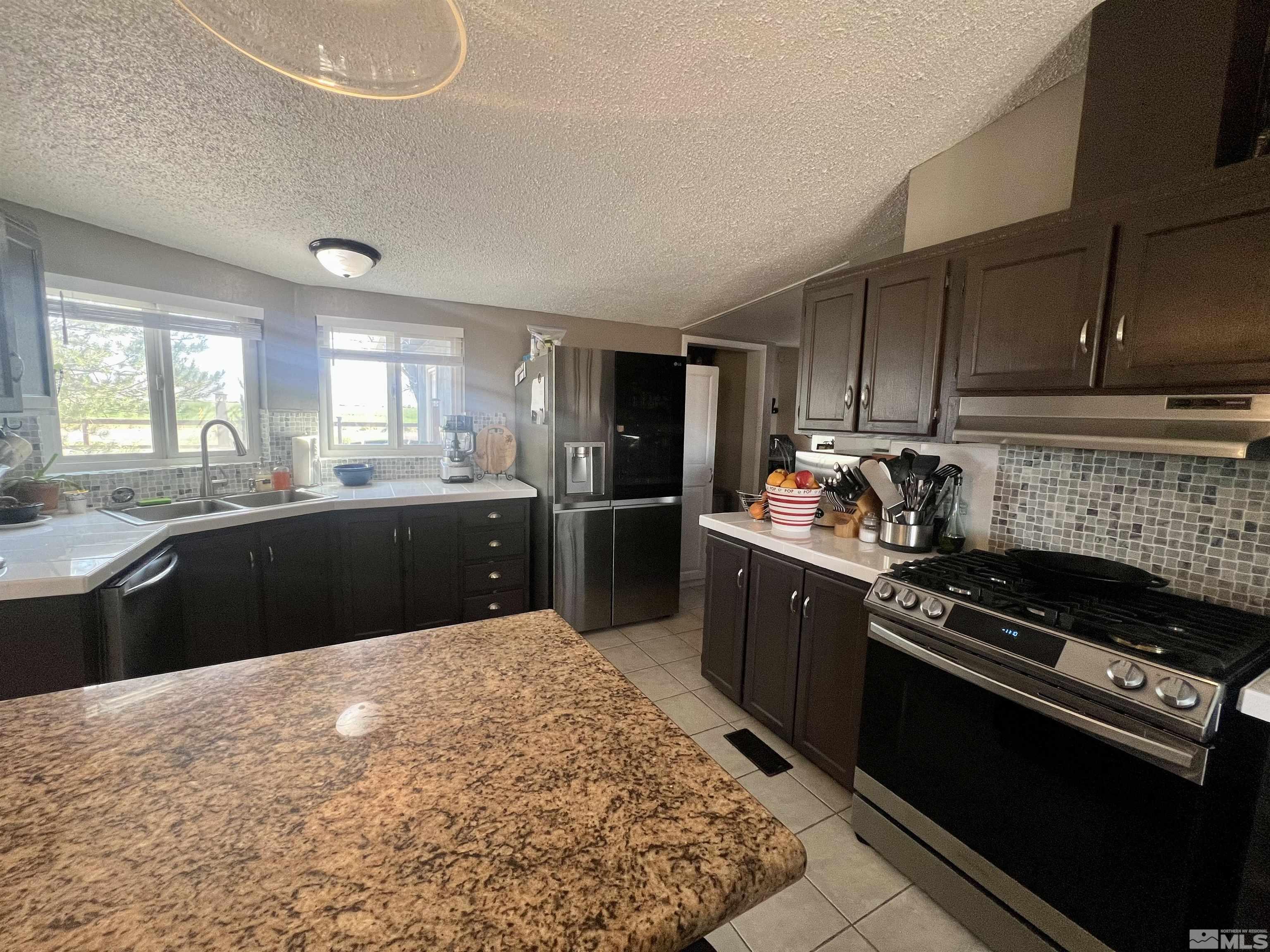 1405 South Meridian Road Lovelock, NV 89419 - Photo 34 of 39 a kitchen with stainless steel appliances kitchen island granite countertop a sink stove and refrigerator