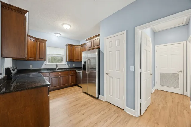 a kitchen with granite countertop a refrigerator and a sink