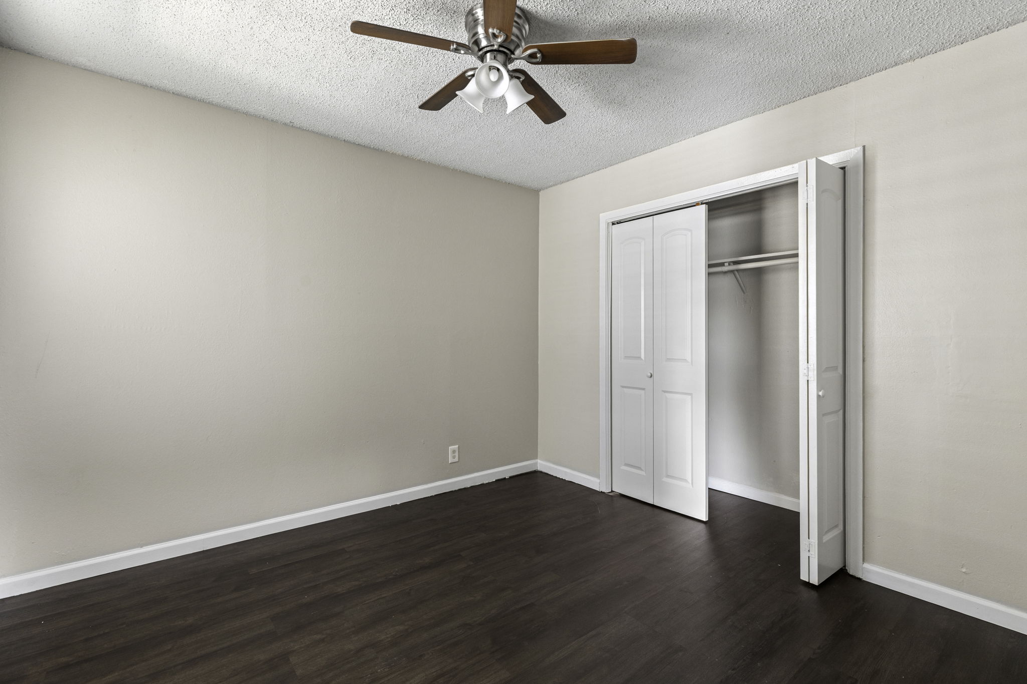 6110 Wheless Cove, Unit F Austin, TX 78723 - Photo 7 of 12 an empty room with wooden floor ceiling fan and windows